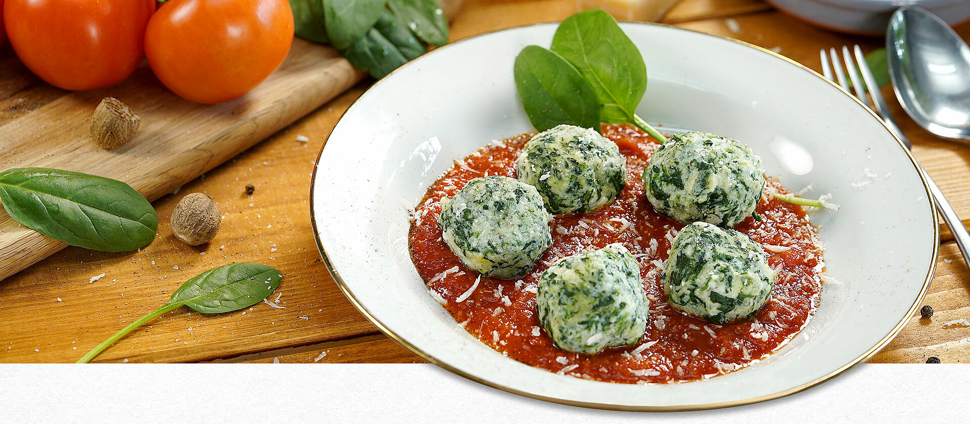 Ein weißer Teller mit Malfatti auf Tomatensauce