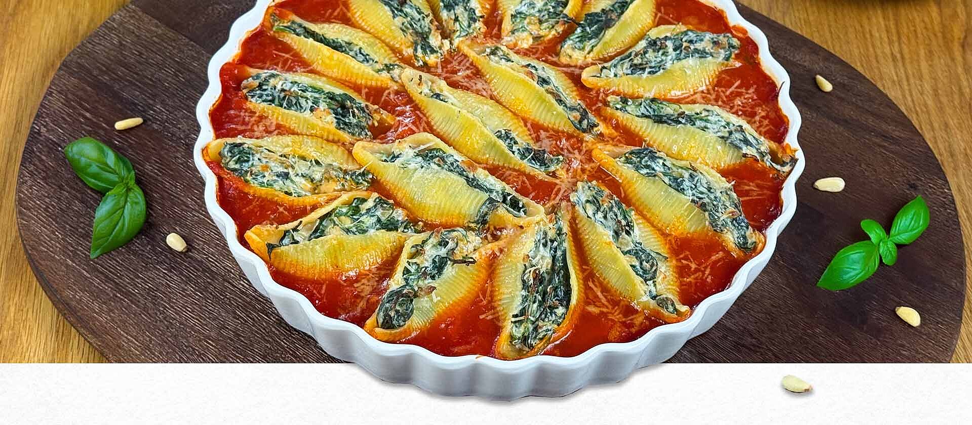 Gefüllte Muschelnudeln mit Spinat und Ricotta in Tomatensoße angerichtet in einer Auflaufform