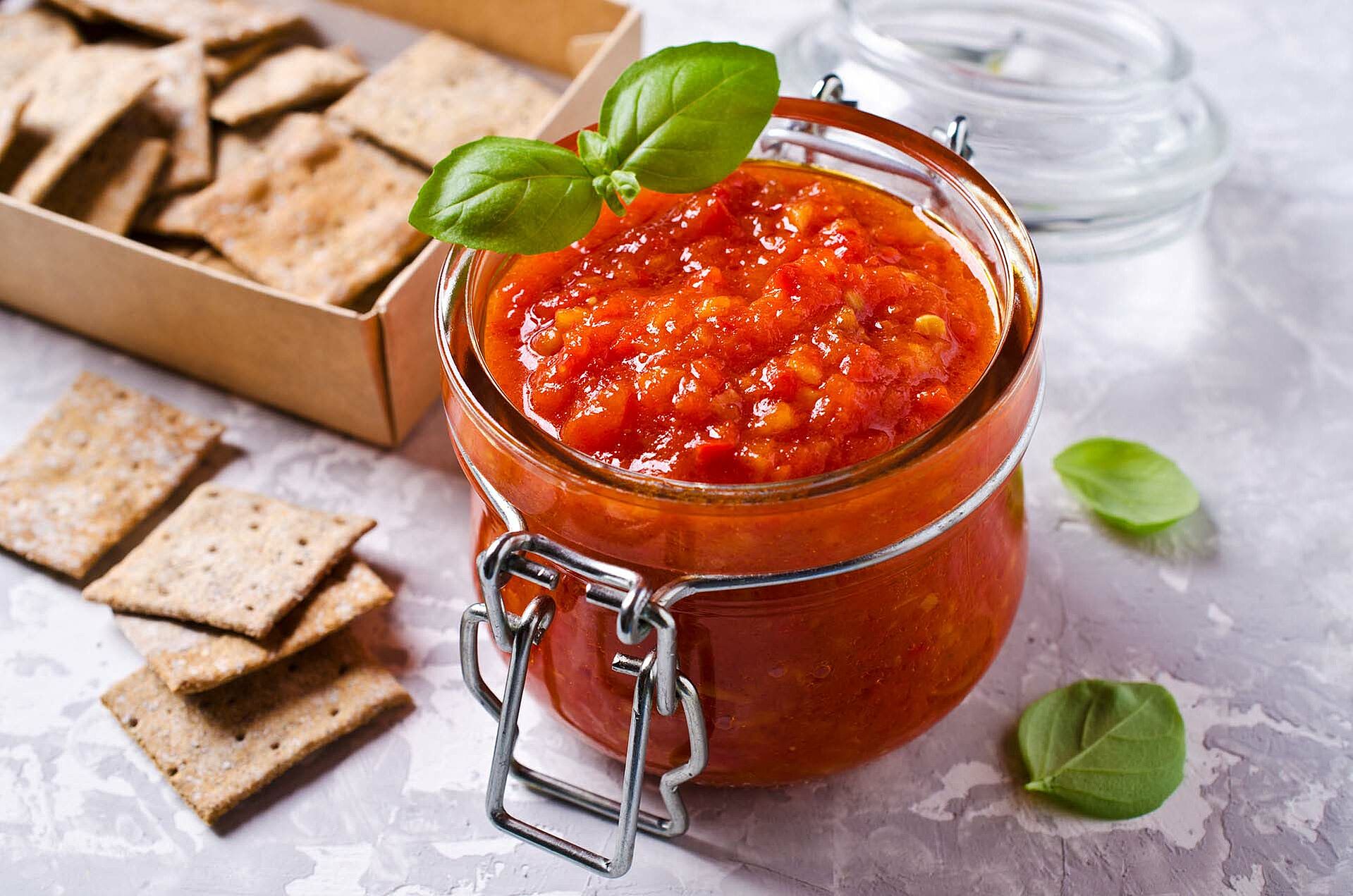 Tomatendip in einem Einmachglas mit Crackern