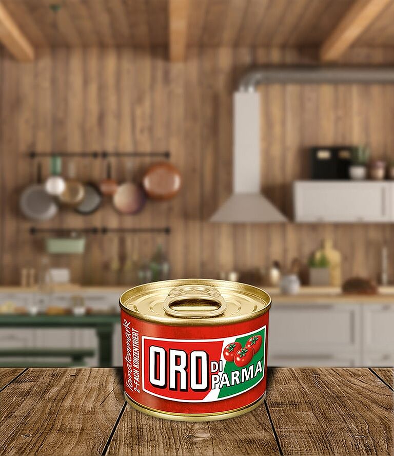 Kleine Dose Tomatenmark steht auf einem Holztisch. Im Hintergrund eine Küche