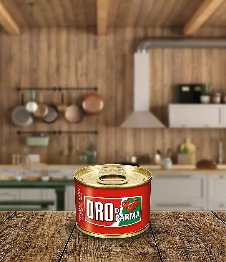 Kleine Dose Tomatenmark steht auf einem Holztisch. Im Hintergrund eine Küche