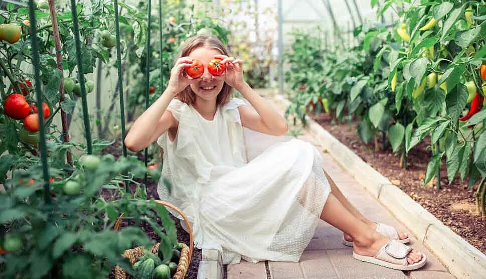 Frau hält sich zwei Tomaten vor die Augen
