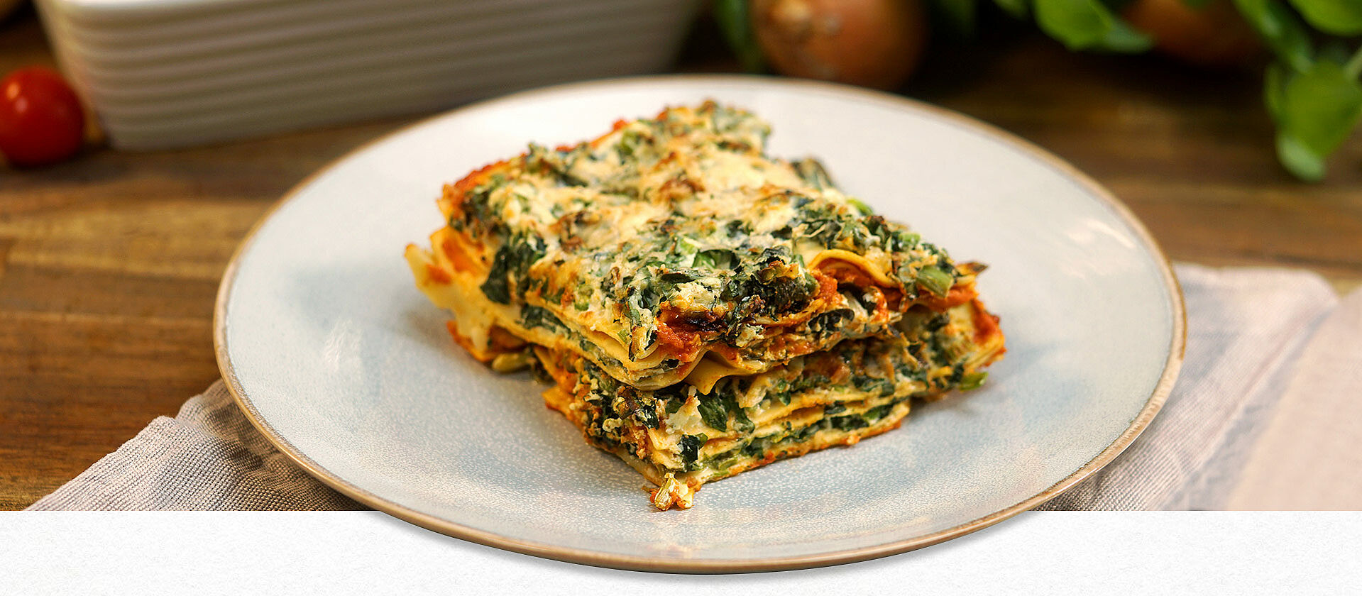 Vegetarische Lasagne mit Spinat und Ricotta angerichtet auf einem Teller