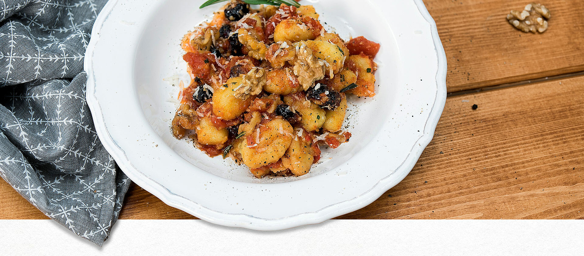 Rosmarin-Gnocchi mit Tomaten-Cranberry-Sauce auf einem Pastateller angerichtet