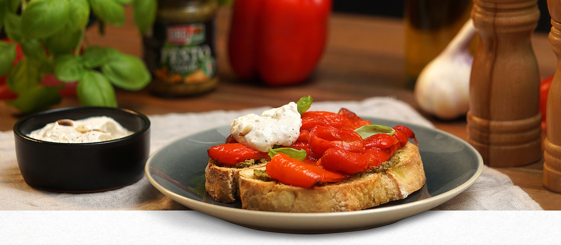 Zwei Scheiben Ciabatta-Brot mit gegrillter Paprika und Ricotta-Pinienkercreme belegt