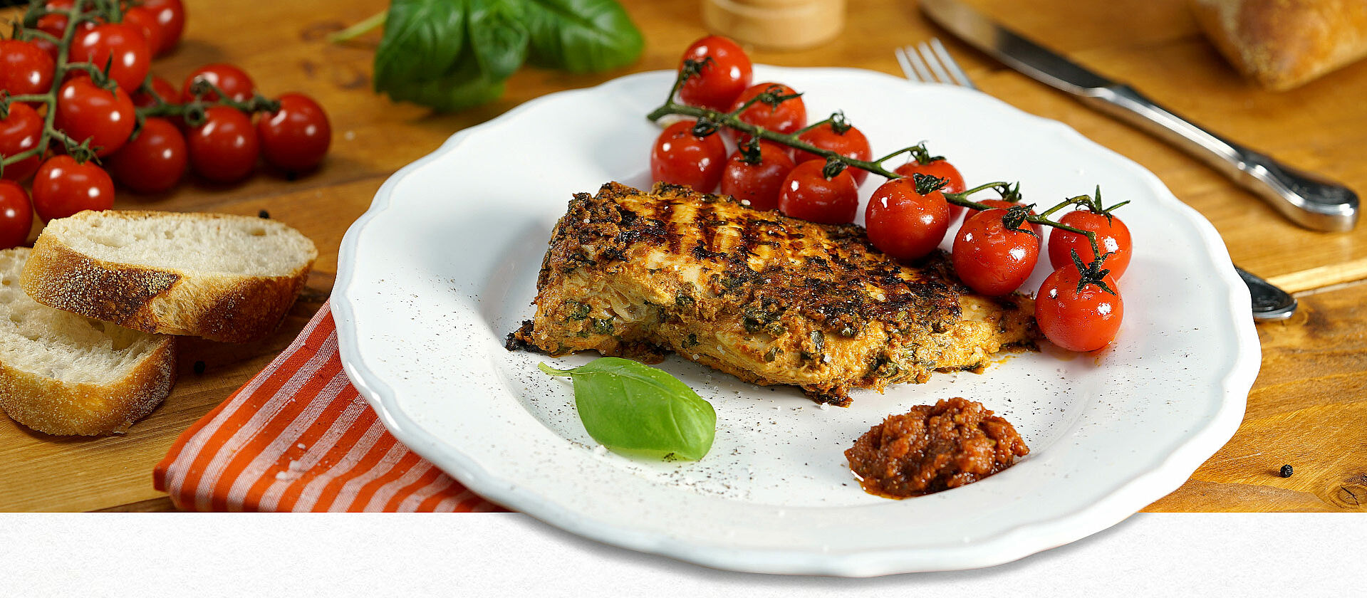 Auf einem Teller liegt ein Hähnchenbrustfilet mit Pesto-Rosso-Joghurt-Marinade