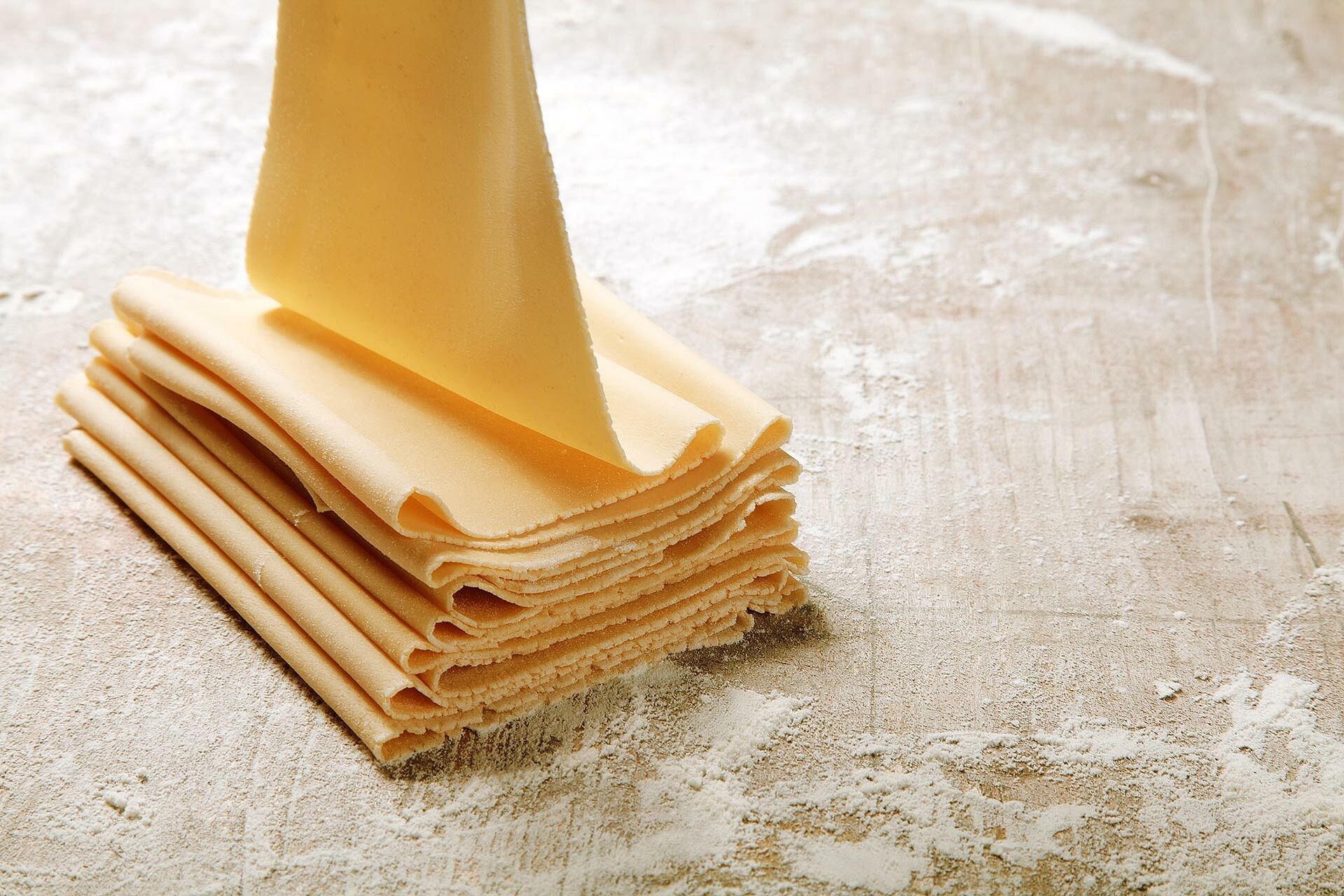 Frischer Pasta Teig auf einer bemehlten Holzfläche