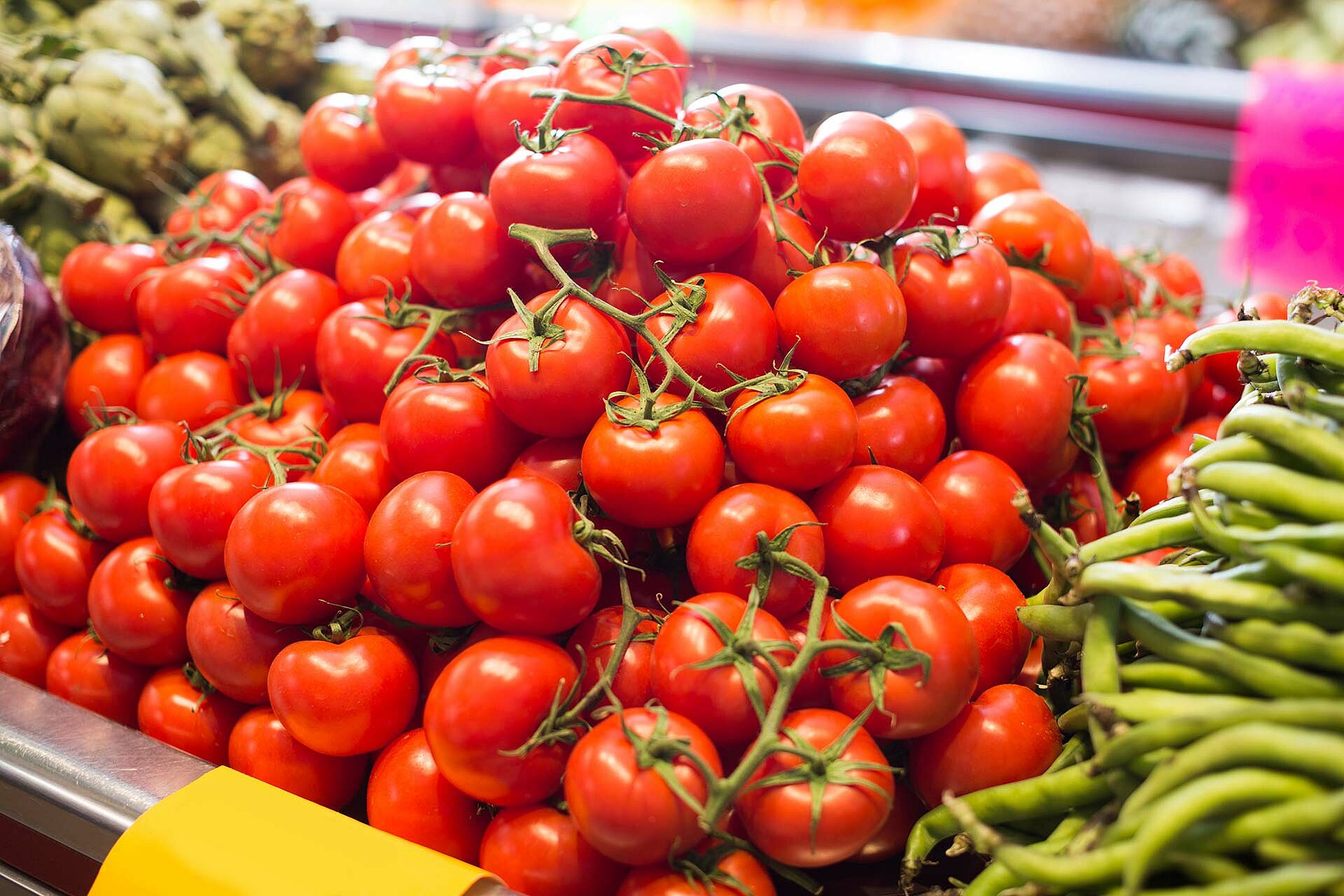 Tomaten im Supermarkt neben anderen Auslagen