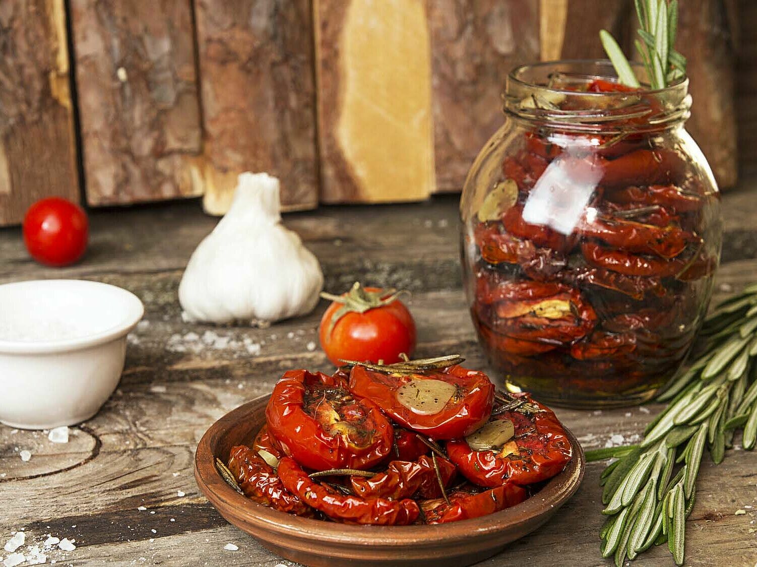 Eingelegte Tomaten in einer Schüssel und einem Einmachglas