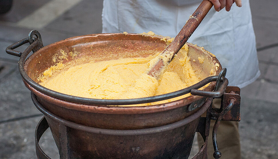 Polenta wird in einem Kessel gerührt