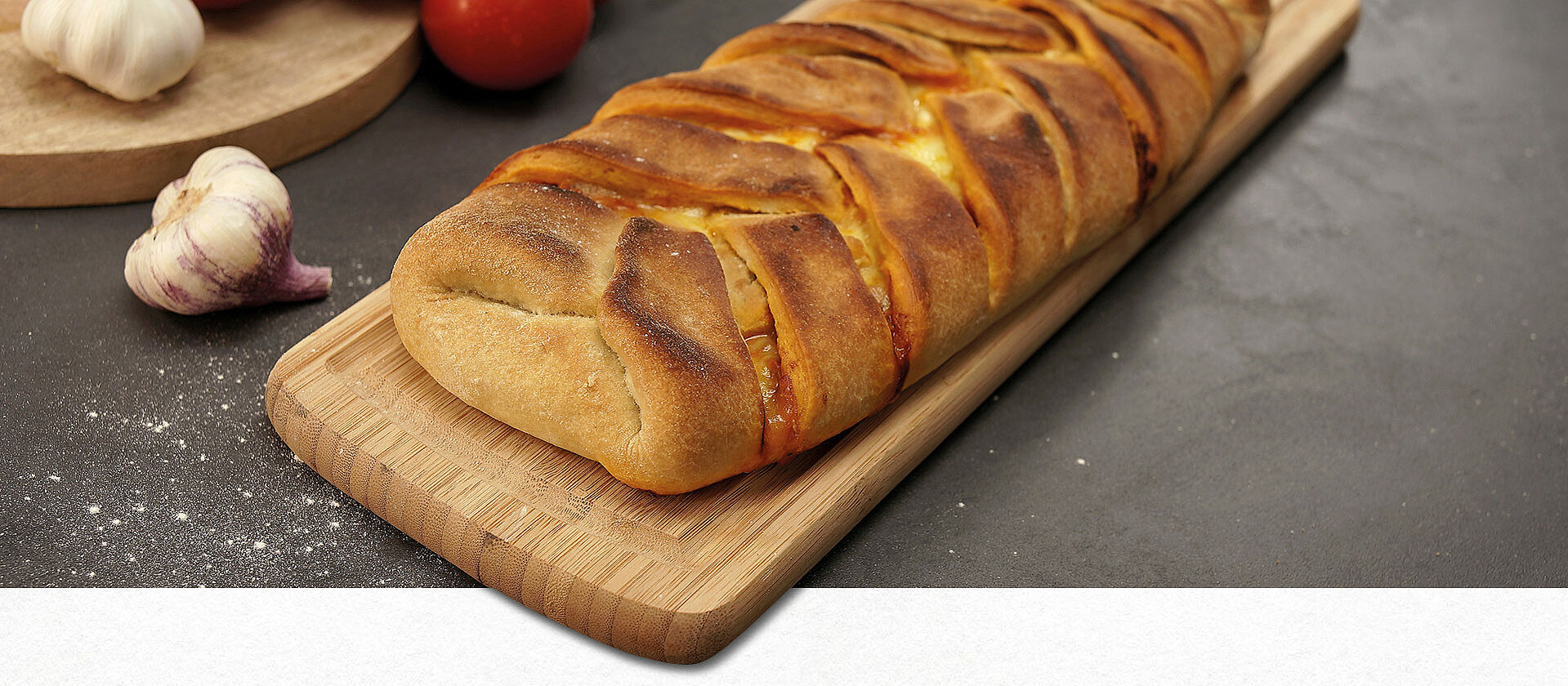 Ein italienischer Strudel mit Hackfleischfüllung auf einem Holzbrett