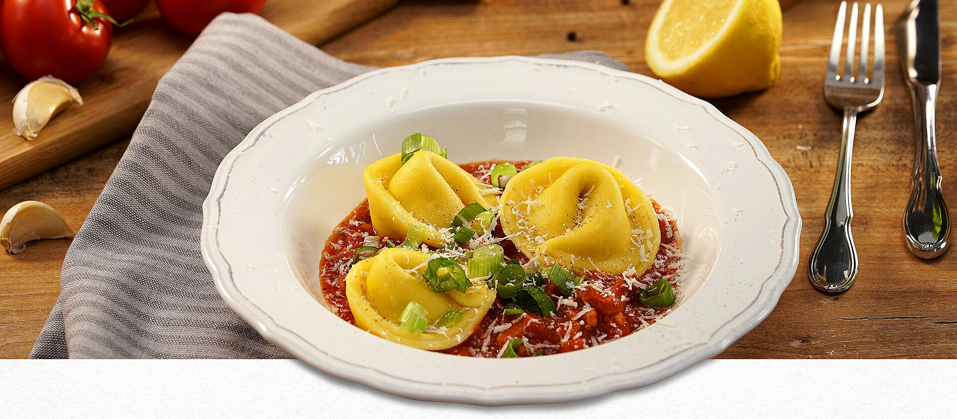 Ein Pastateller gefüllt mit Tortellini auf Tomaten-Bacon-Sauce