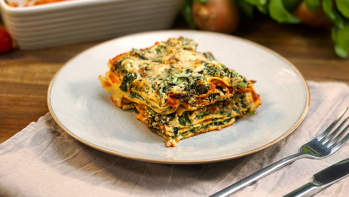 Vegetarische Lasagne mit Spinat und Ricotta angerichtet auf einem Teller