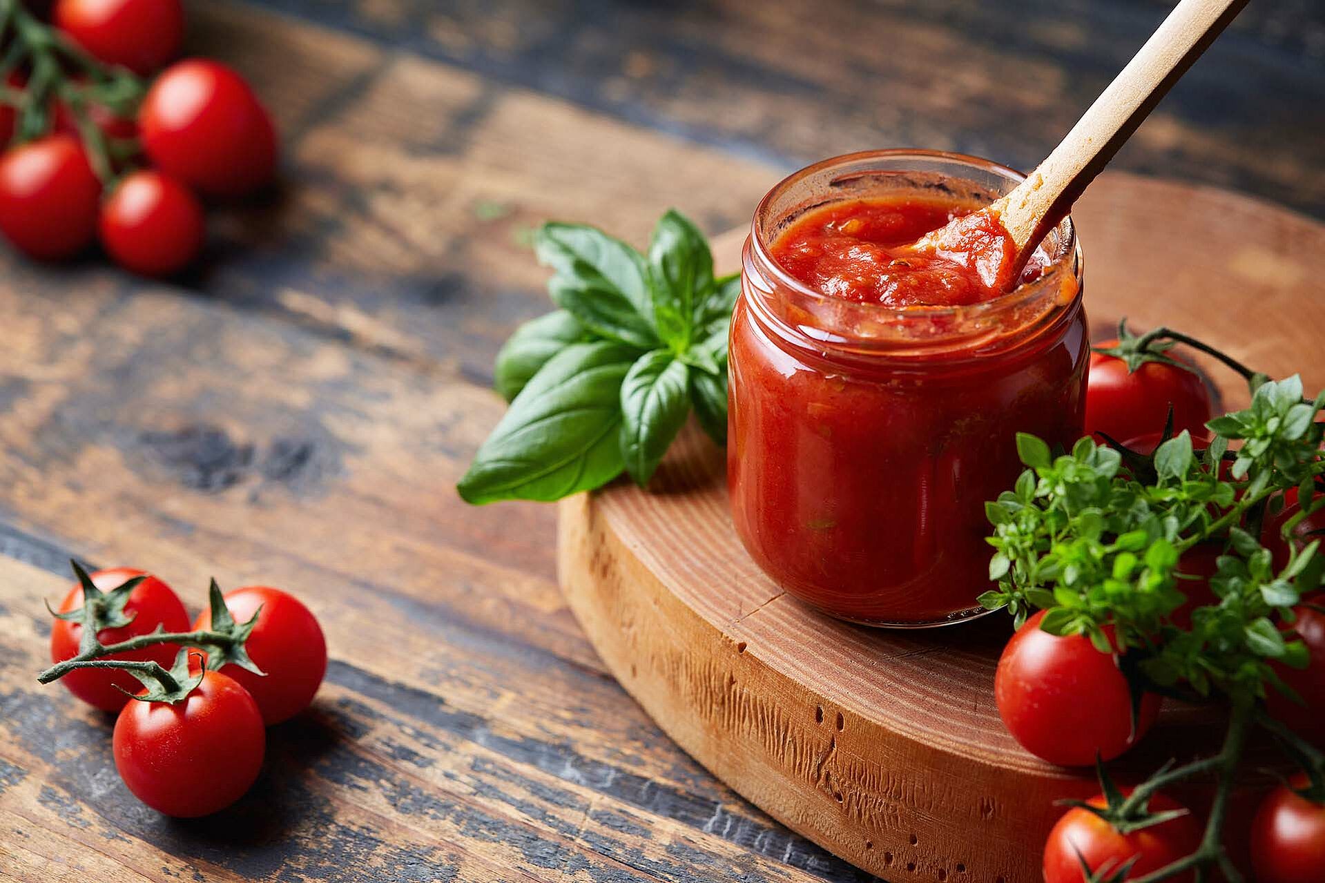 Fruchter Tomaten-Dip in einem Glas abgefüllt mit einem Löffel darin.
