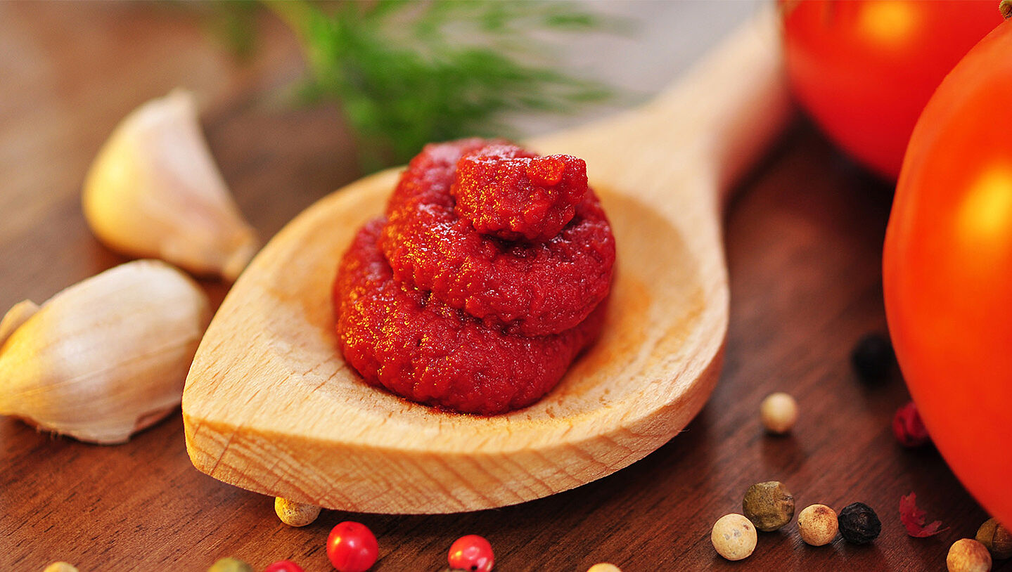 Tomatenmark auf einem Holzlöffel