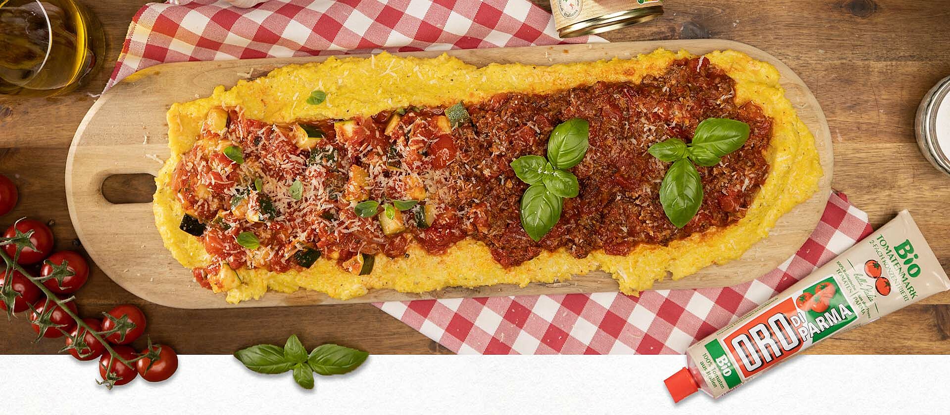 Eine Polenta sul tavolo mit zwei Toppings auf einem Holzbrett