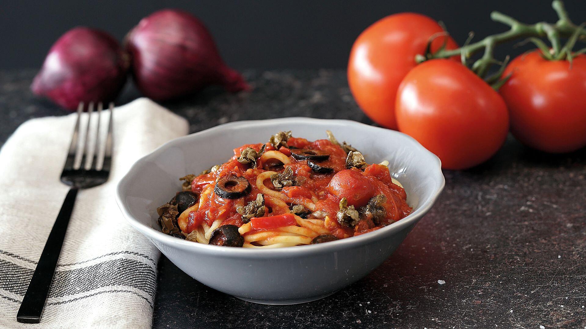 Eine Schüssel mit Spaghetti in Tomatensauce und Oliven
