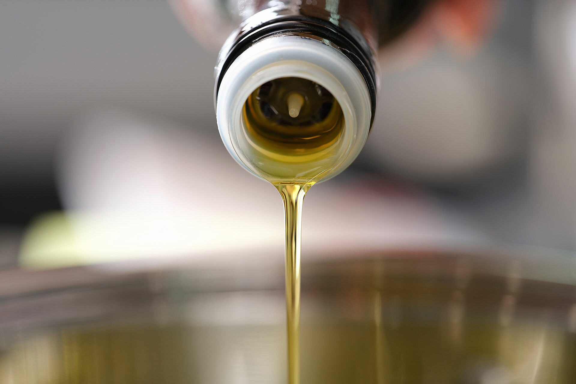 Olivenöl fließt aus einer Flasche