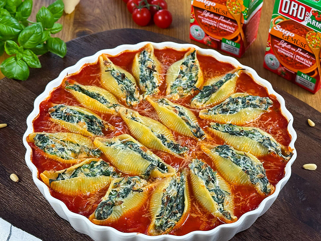Gefüllte Muschelnudeln mit Spinat und Ricotta in Tomatensoße angerichtet in einer Auflaufform