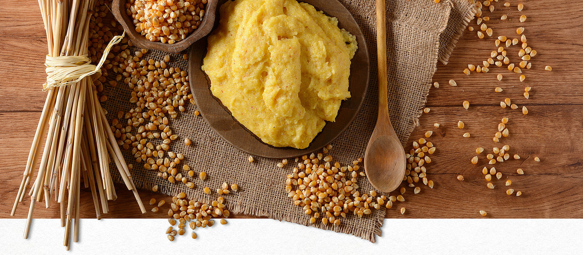 Polenta und Maiskörner auf einem Holztisch