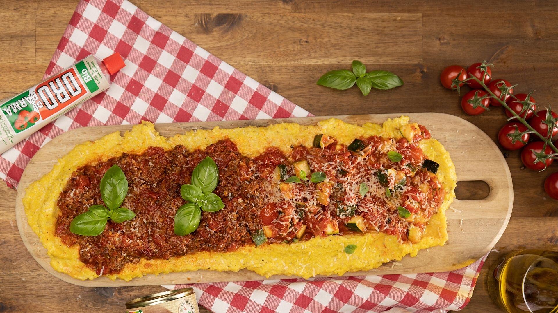 A plate of polenta with two toppings served on a wooden board