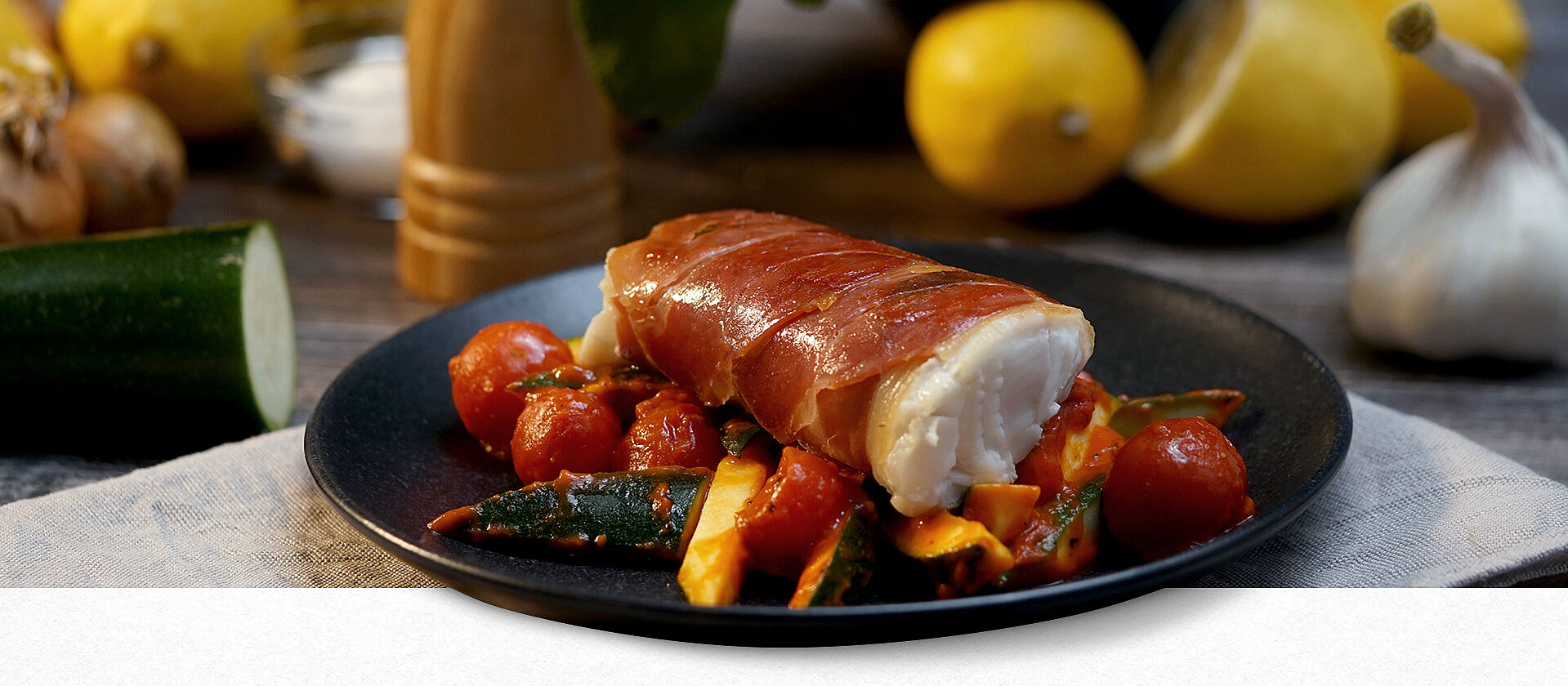 Kabeljau Saltimbocca auf einem Teller mit Beilagen