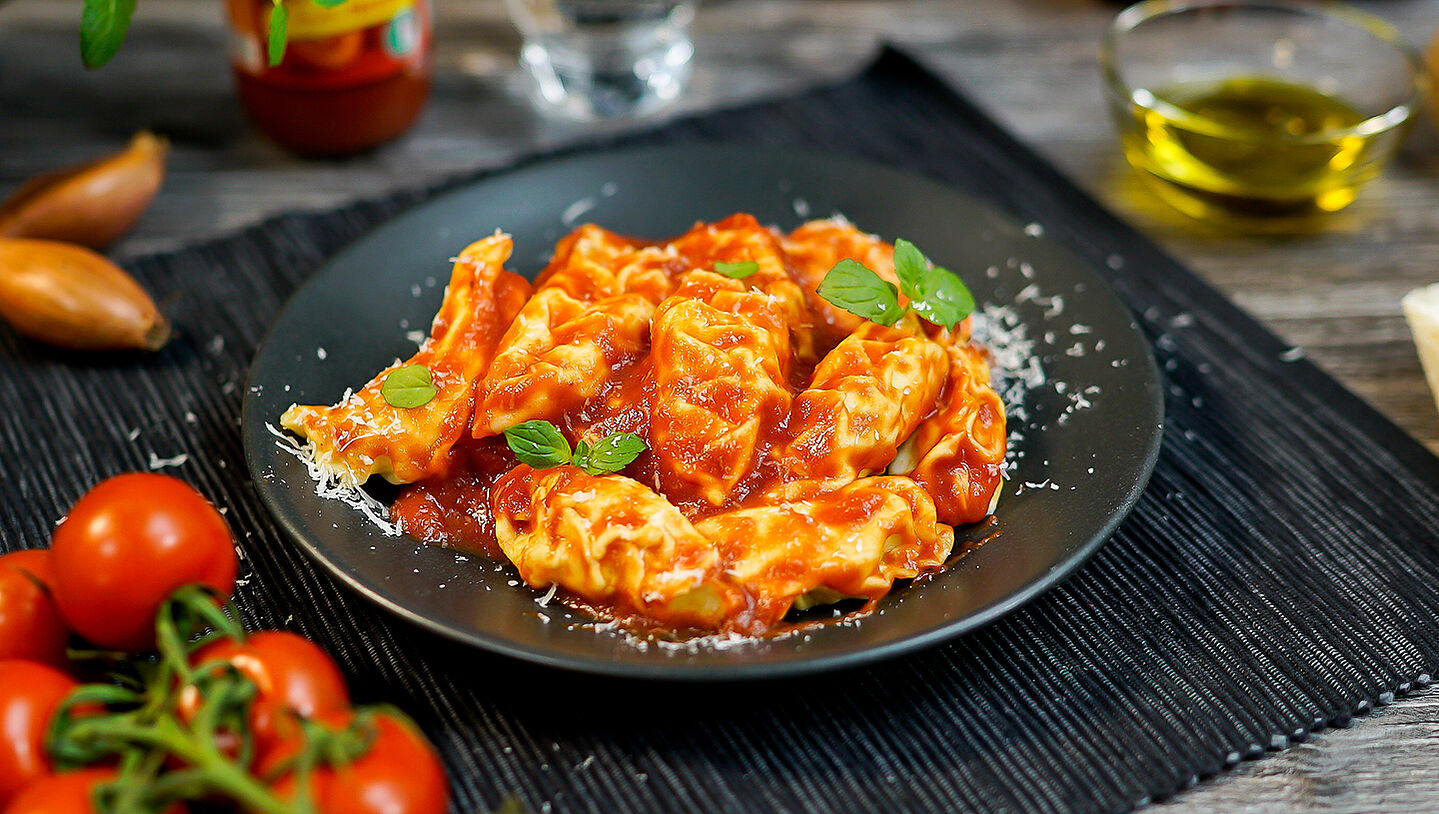 Ein Teller mit Culurgiones - sardischen Ravioli in Tomatensauce