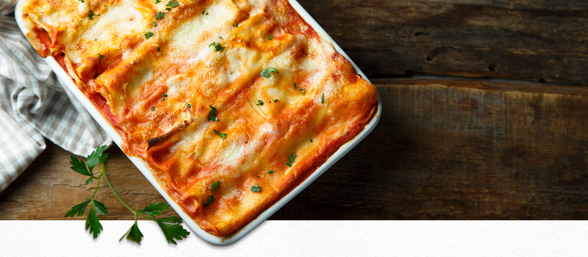 Italienische Lasagne in einer Auflaufform auf einem Holztisch