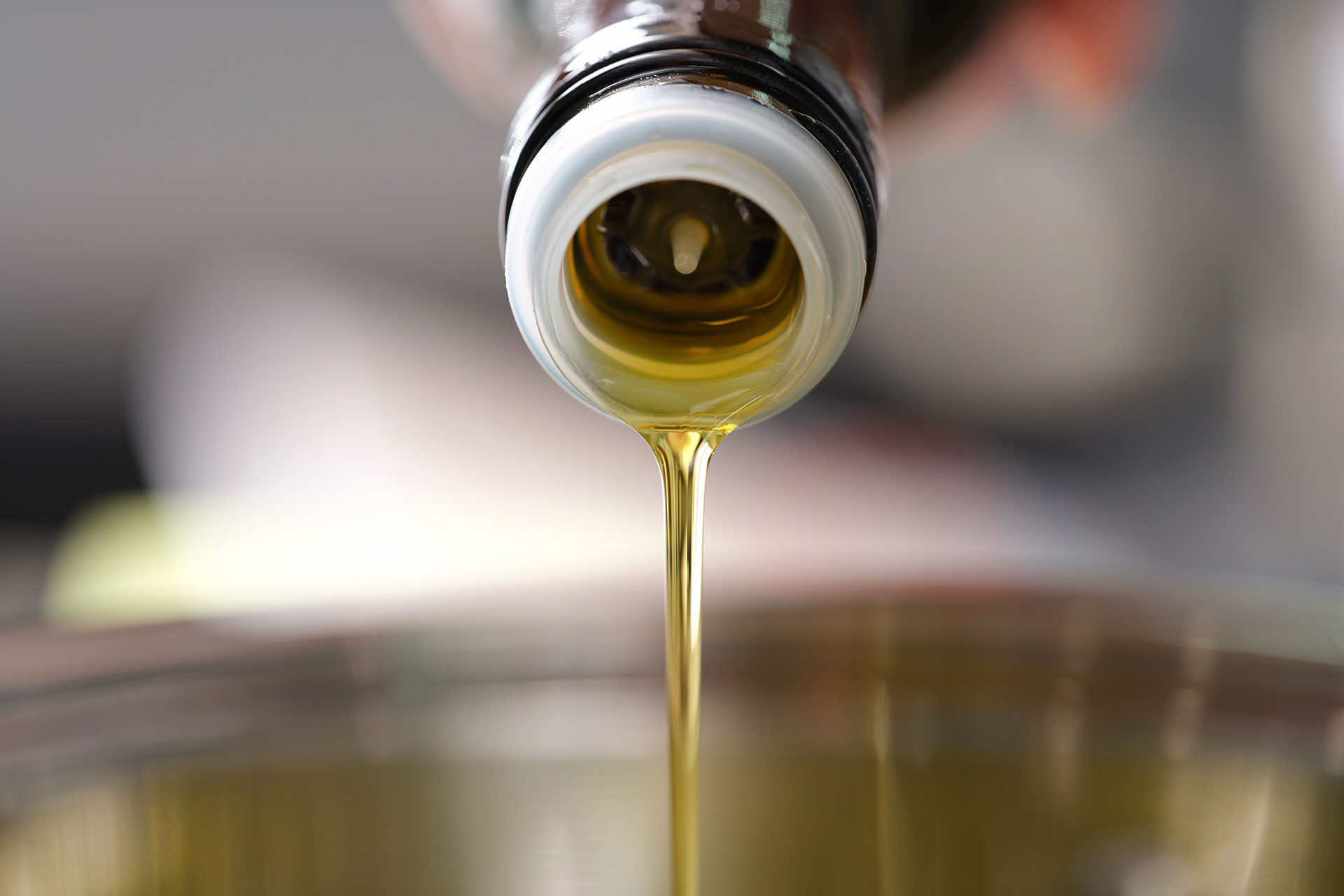 Olivenöl fließt aus einer Flasche