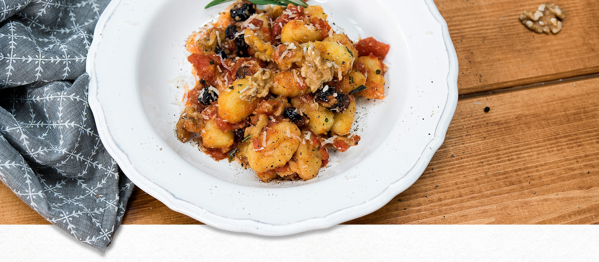Rosmarin-Gnocchi mit Tomaten-Cranberry-Sauce auf einem Pastateller angerichtet