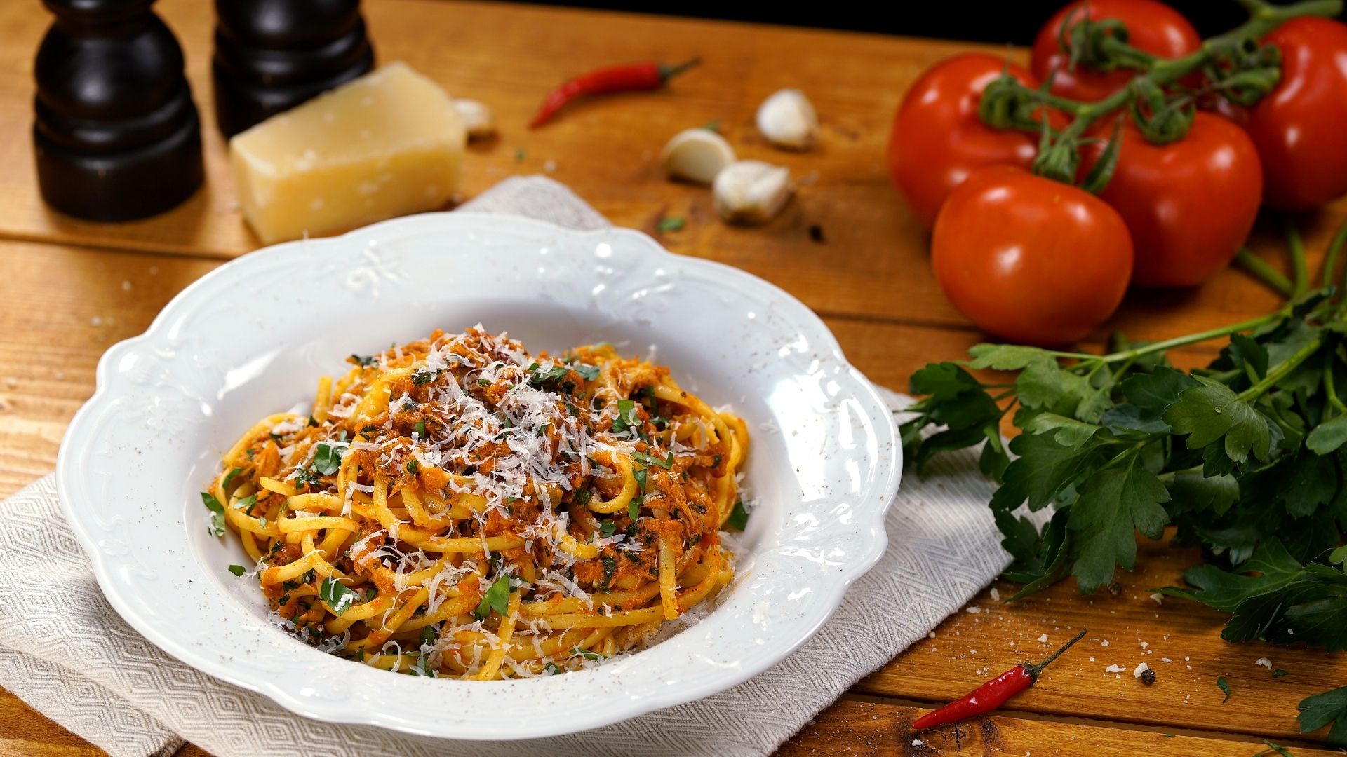 Linguine mit Thunfisch auf einem Pastateller mit geriebenem Parmesan garniert