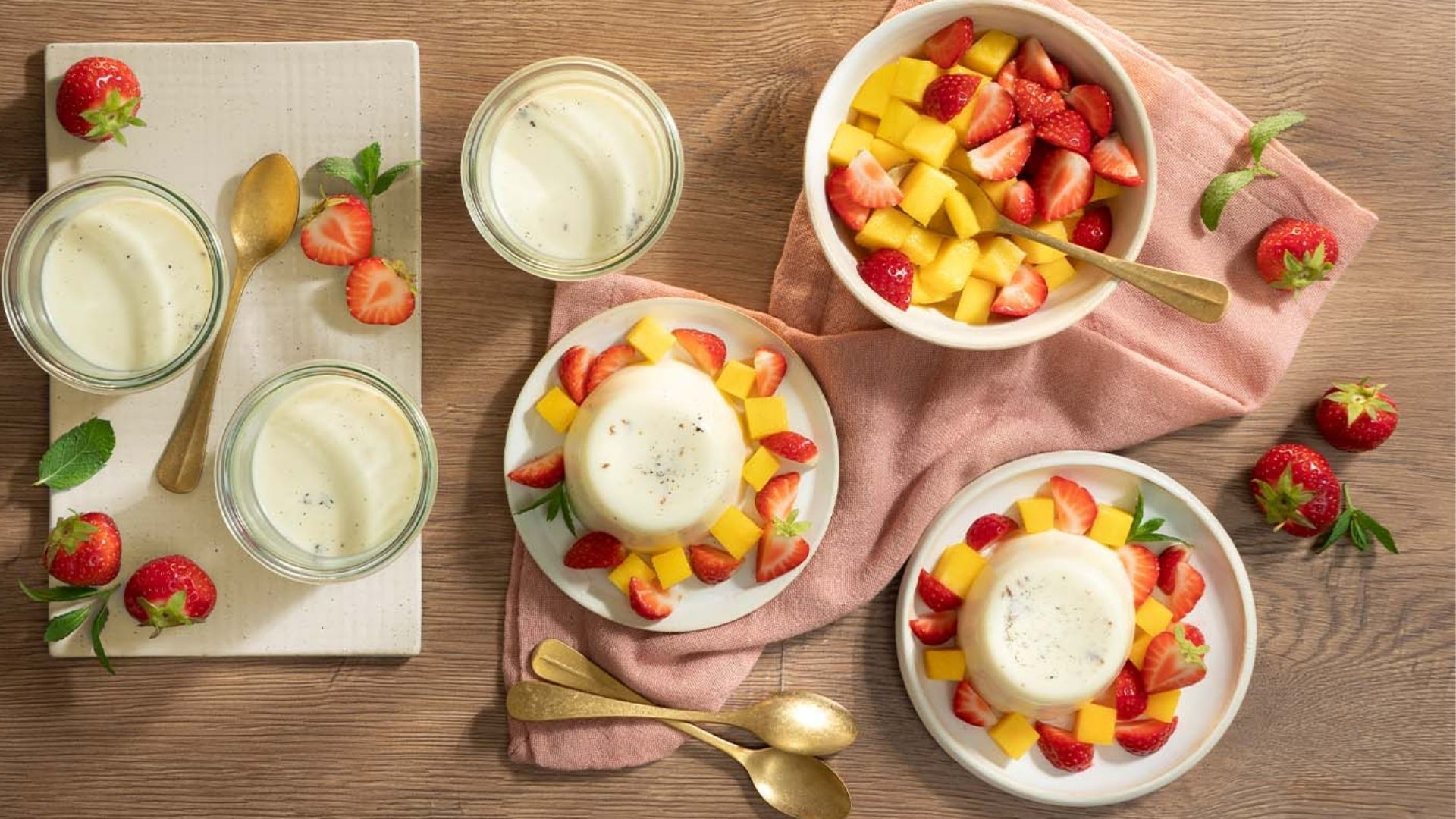 Dessert im Glas: Auf einem Teller steht ein Glas gefüllt mit Limoncello Panna Cotta und Mango-Topping