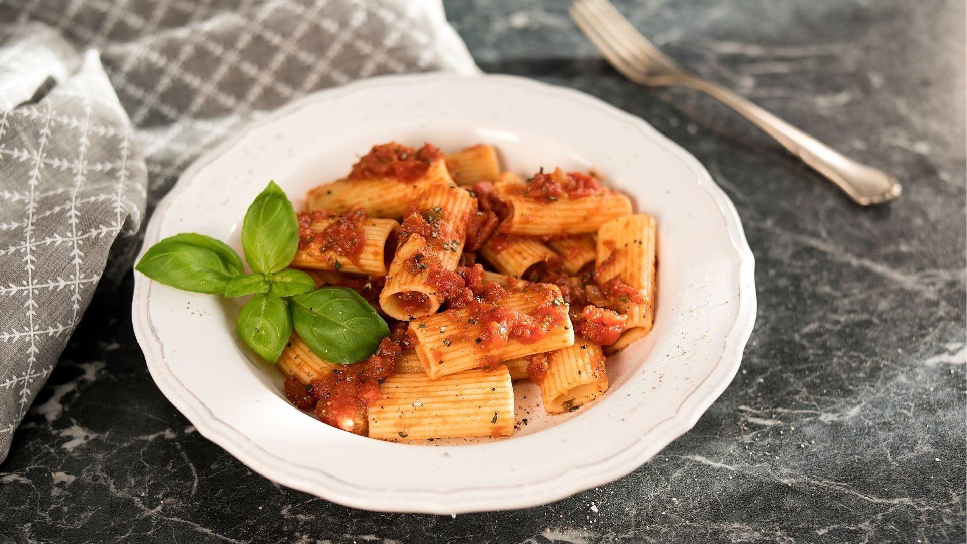 Ein weißer Pastateller mit Rigatoni in Balsamico-Tomatensauce 