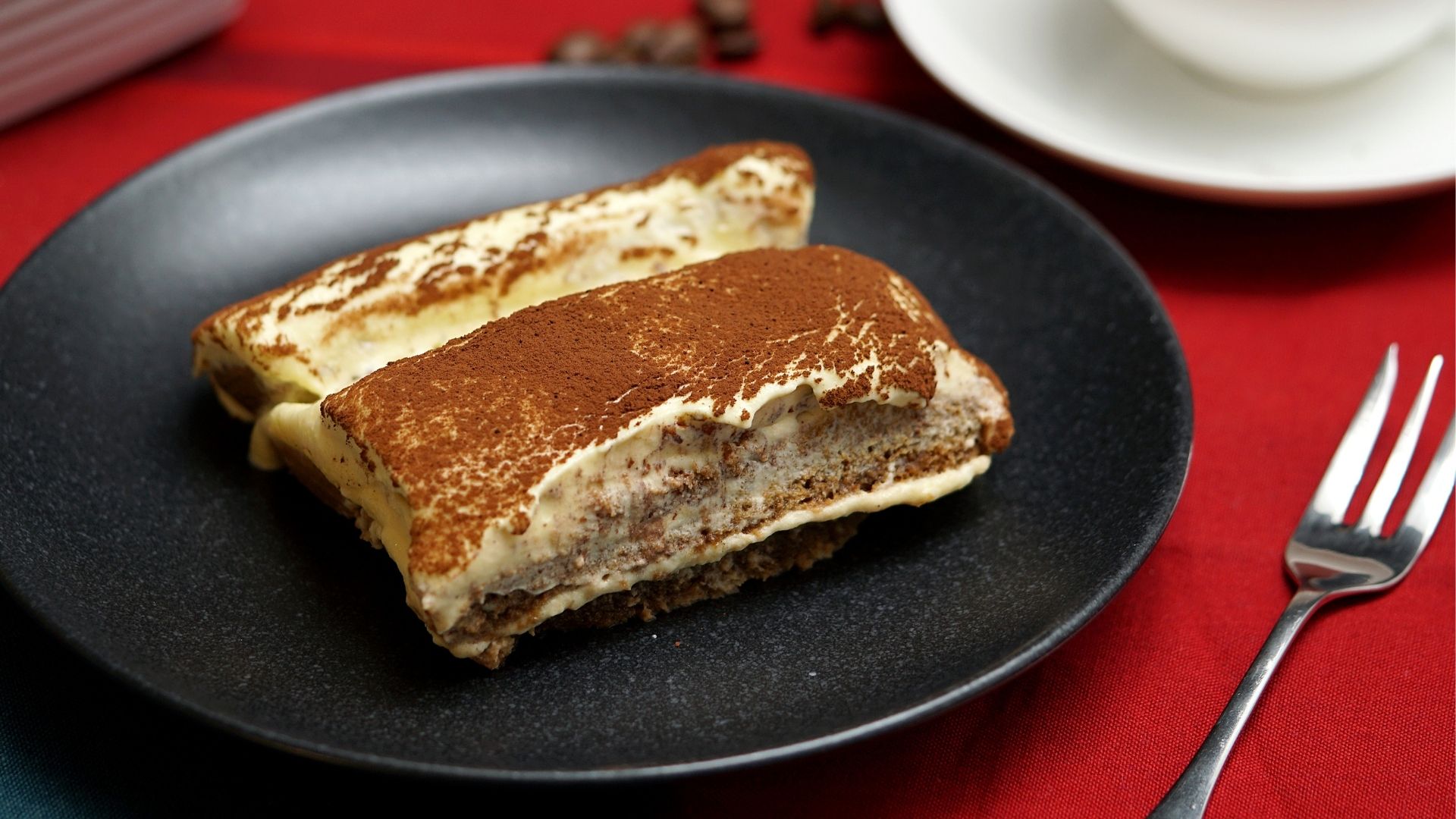 Italienisches Tiramisu angerichtet auf einem schwarzen Teller