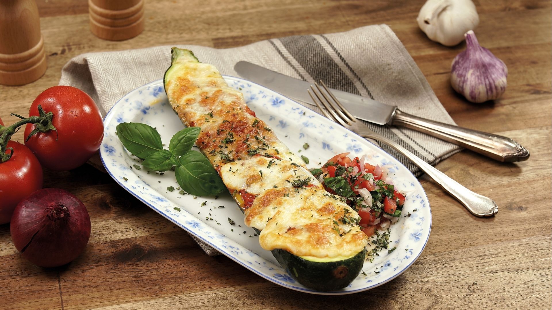 Eine Servierplatte mit einem gratiniertem Zucchinischiffchen