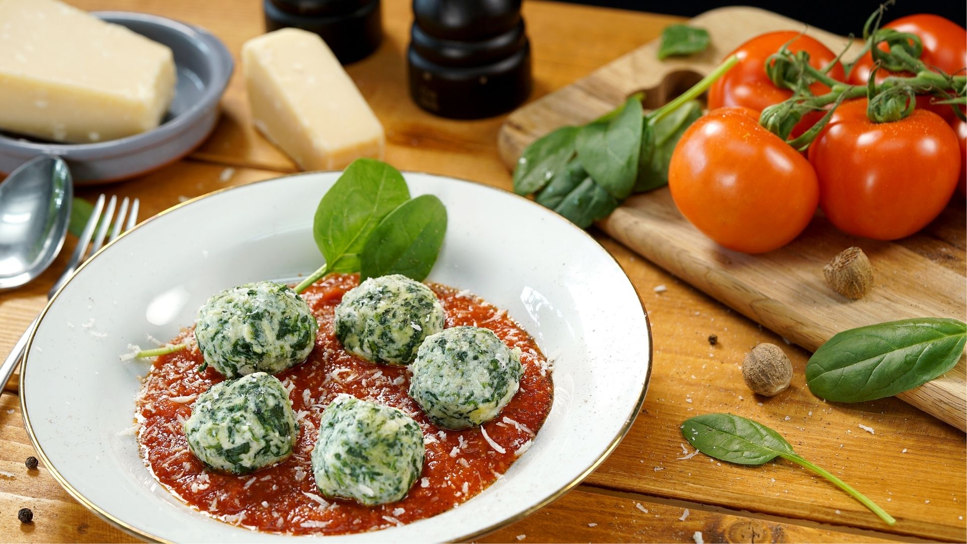 Ein weißer Teller mit Malfatti auf Tomatensauce