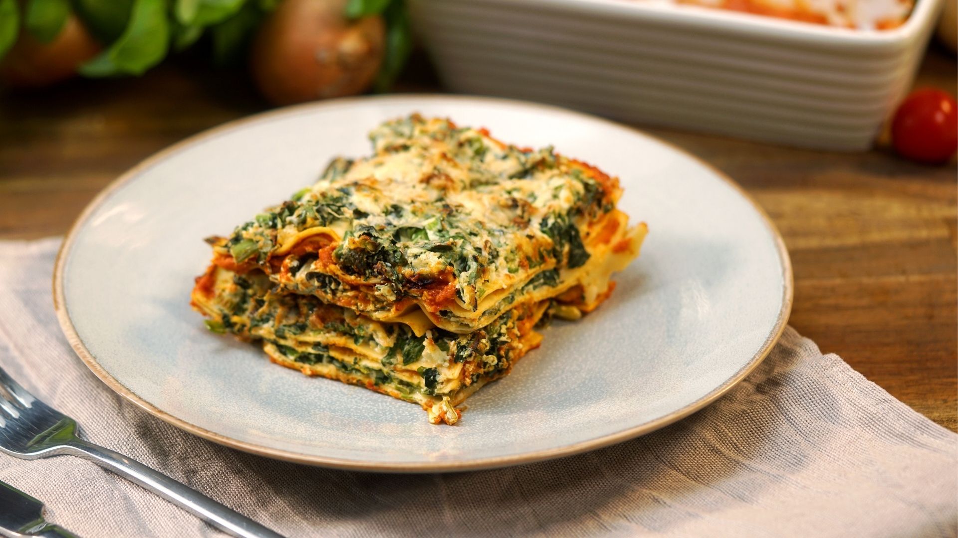 Vegetarische Lasagne mit Spinat und Ricotta angerichtet auf einem Teller