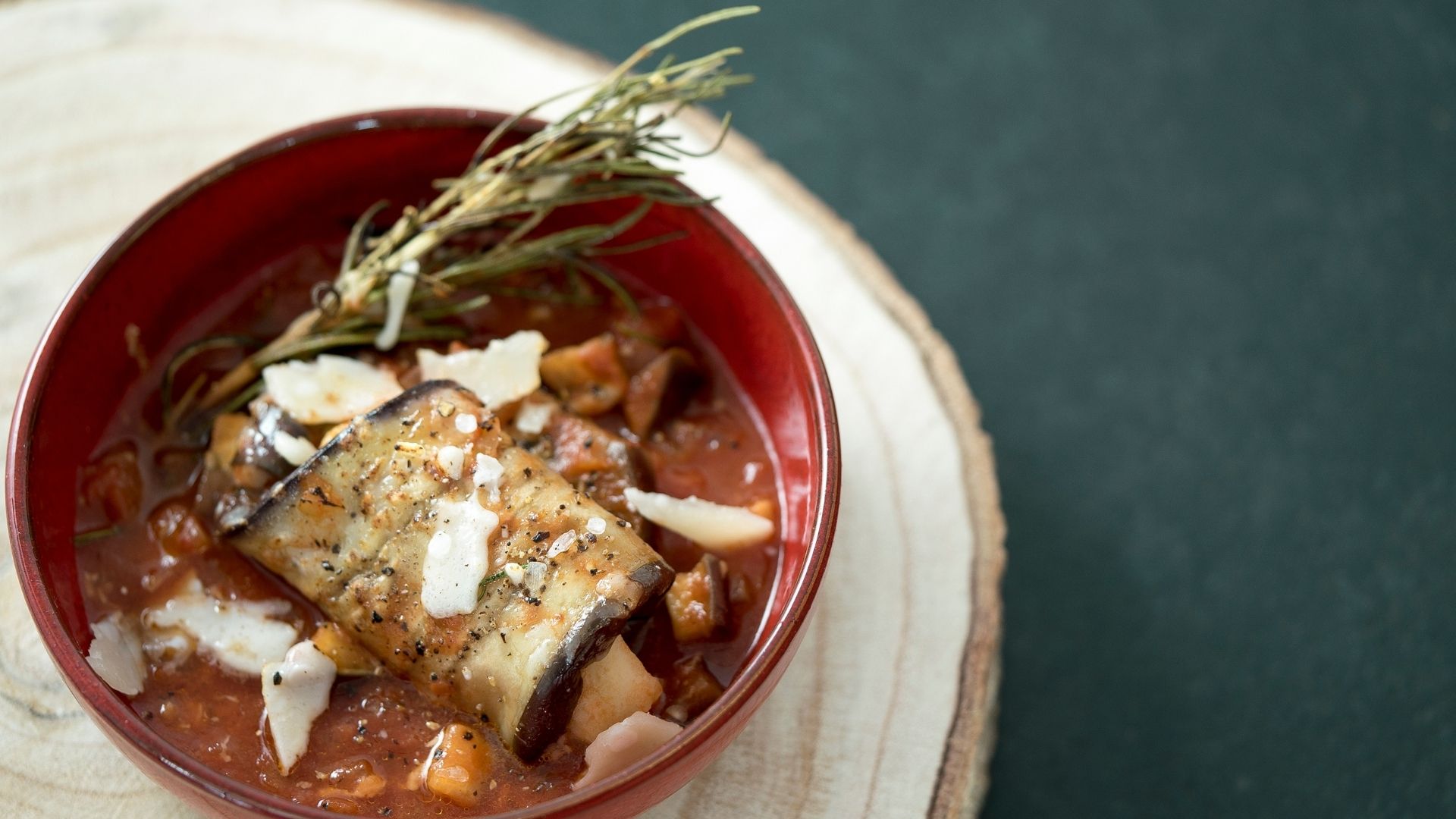 Ein geschmortes Auberginenröllchen in Tomatensauce in einer Schüssel